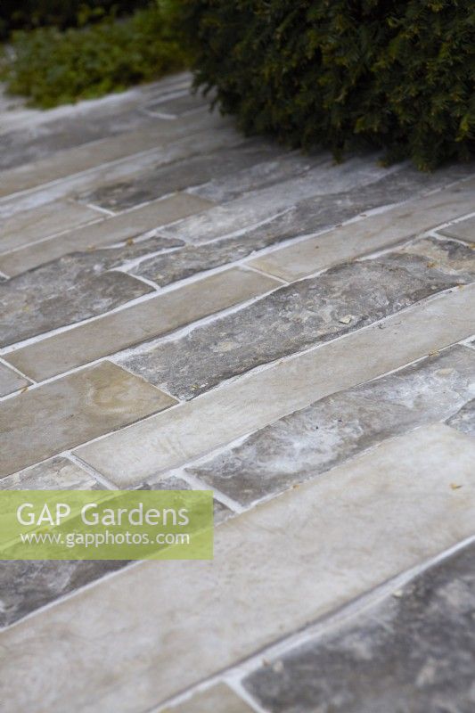 Pathway of pale contemporary slabs of different tones and textures.