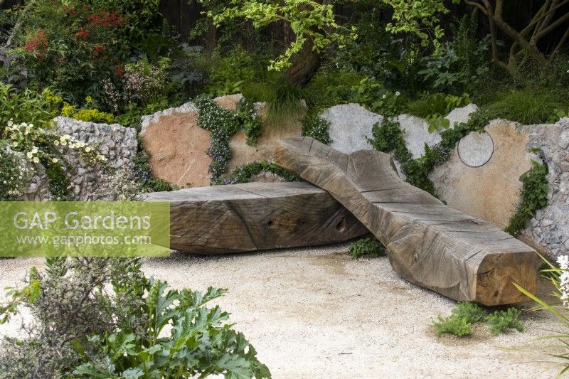 A sculptural wooden bench in the Samaritans' Listening Garden - designer Darren Hawkes - RHS Chelsea Flower Show 2023