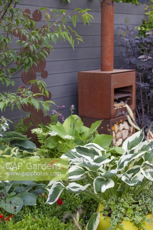 Yellow planter with hosta and hedera helix in 'A Breath of Fresh Air' garden at BBC Gardener's World Live 2018