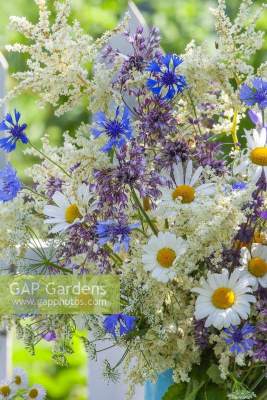 Summer flower bouquet containing daisies, cornflowers and other wild flowers.
