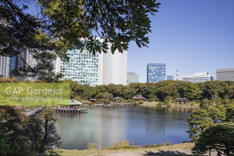 View across lake to city buildings beyond with building called Nakajima-no-ochaya centre left. 