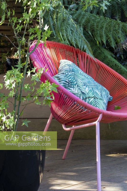 A contemporary styled chair adds colour to the garden.