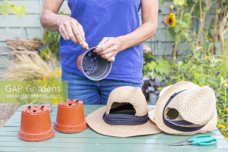 Woman using bradawl to poke holes in the plastic pots