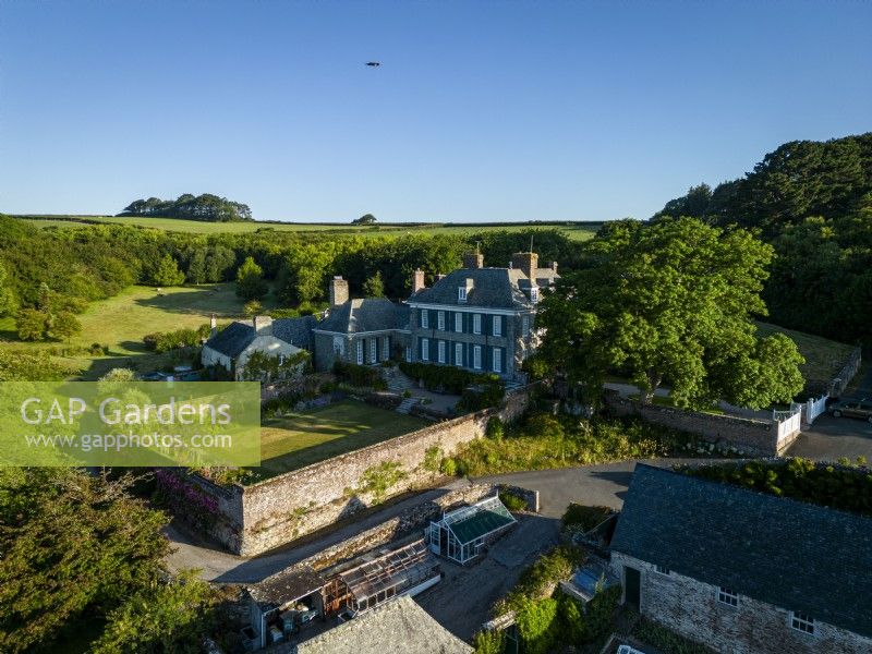 Aerial view of Mothecombe House in Devon, a Queen Ann building with extensive gardens set in rolling Devon countryside