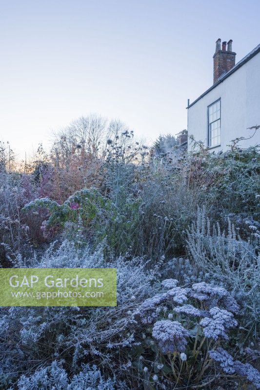 Period house and garden in winter. Part of a sequence comparing the same scene in all 4 seasons. Borders have shrubs and perennials as structure through the winter.