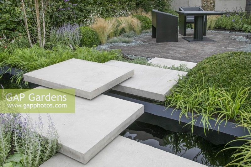 Bridge leading to seating area in 'Shades of Grey' at BBC Gardener's World Live 2021 - urban contemporary garden using different grey hard landscaping materials, August