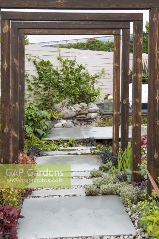Wooden pergola in 'A Glimpse of South East Asia' garden at BBC Gardeners World Live 2019, June