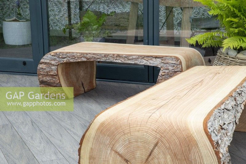 Log bench seats made from tree trunks on a composite decking area