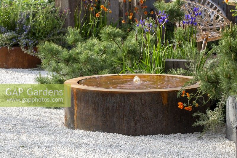 Corten steel water feature on a gravel path surface