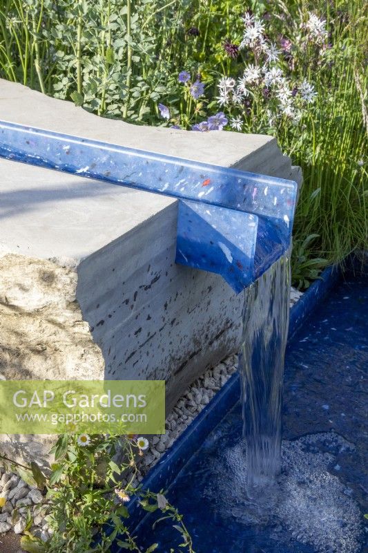 A modern contemporary water rill made from recycled plastics set in stone 
