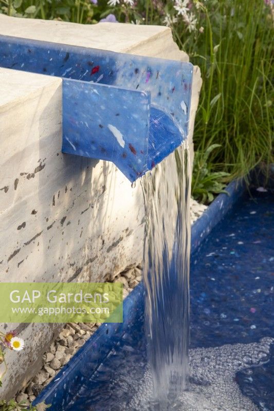 A modern contemporary water rill made from recycled plastics set in stone 