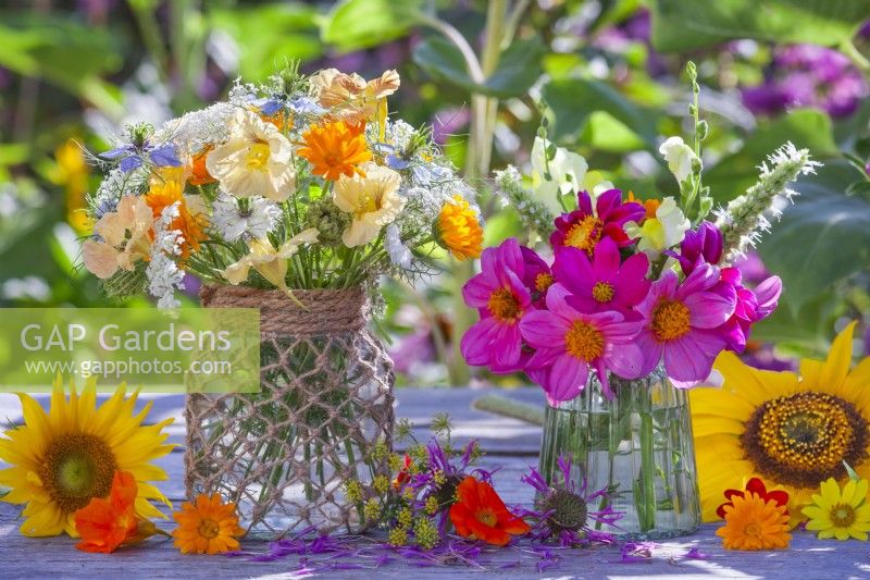 Bouquet with Cosmos in a glass vase and  annual flower bouquet featuring Nasturtium, Pot marigold, Wild carrot and Love in a mist in a glass jar decorated with twine.