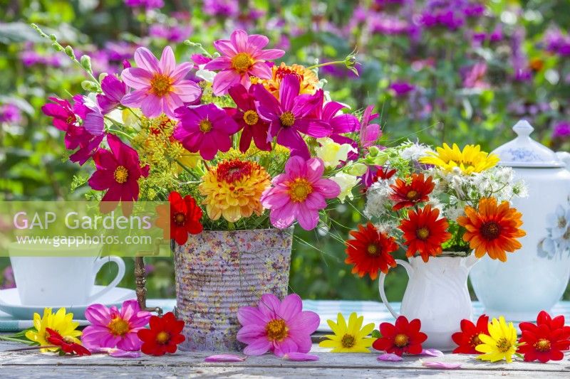 Sumer flower bouquets in milk jug and tin can vase containing Cosmos, Dahlia, Helianthus, Clematis seedheads and Fennel.