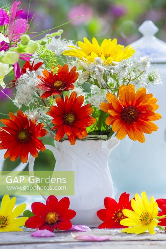Flower bouquet in milk jug with Heliopsis helianthoides, Clematis seedheads and Sunflower.