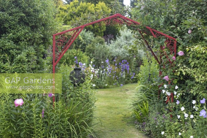 Red metal arch in garden open for Charity, Whittington, June
