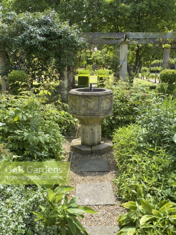 Old font surrounded by mixed herbaceous beds