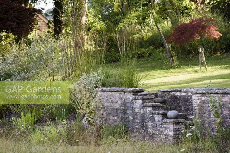 Stone wall and steps in a country garden in July