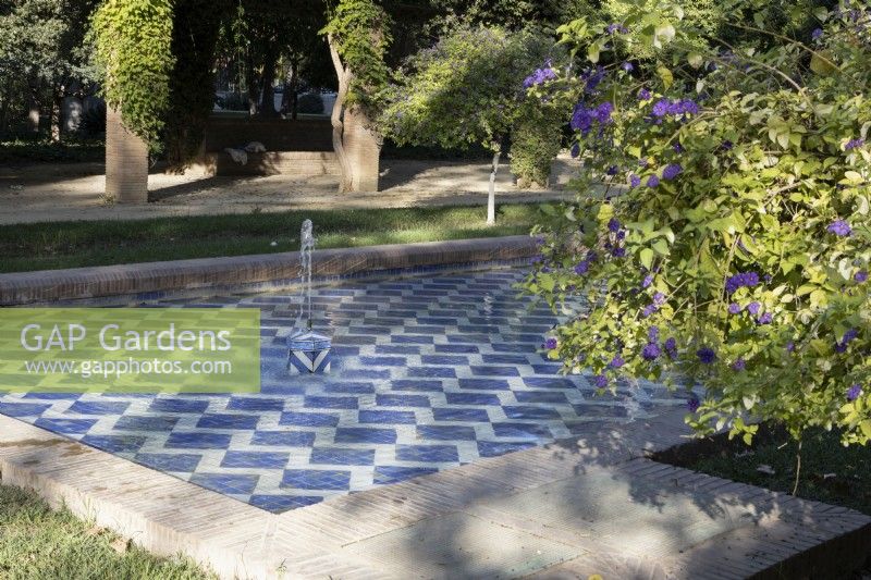 A blue and white tiled pool with two fountains. Parque de Maria Luisa, Seville, Spain. September