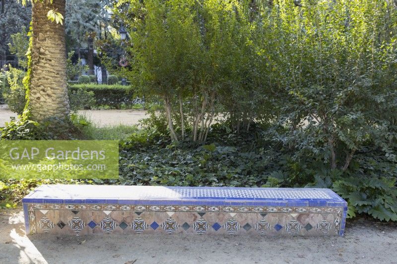 A low, colourful glazed tile bench. Parque de Maria Luisa, Seville, Spain. September