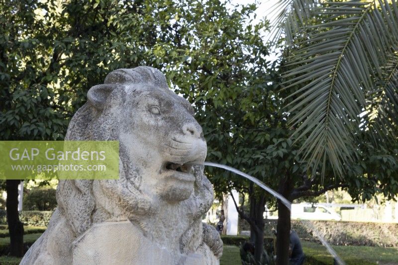 A lion statue spouts water. Parque de Maria Luisa, Seville, Spain. September