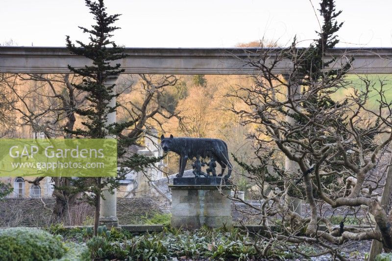 Statue of Romulus and Remus being suckled by the wolf framed by the colonnade on the Great Terrace at Iford Manor in January