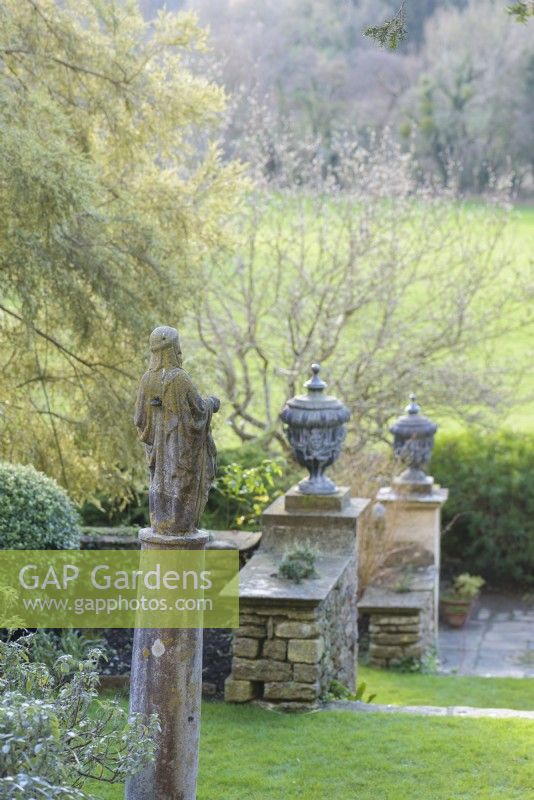 Sculptures and urns punctuating terraces at Iford Manor in January