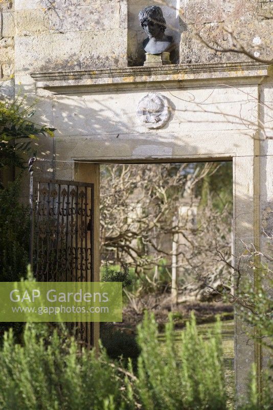 Entranceway between front and main garden  at Iford Manor in January with bust of a young man above