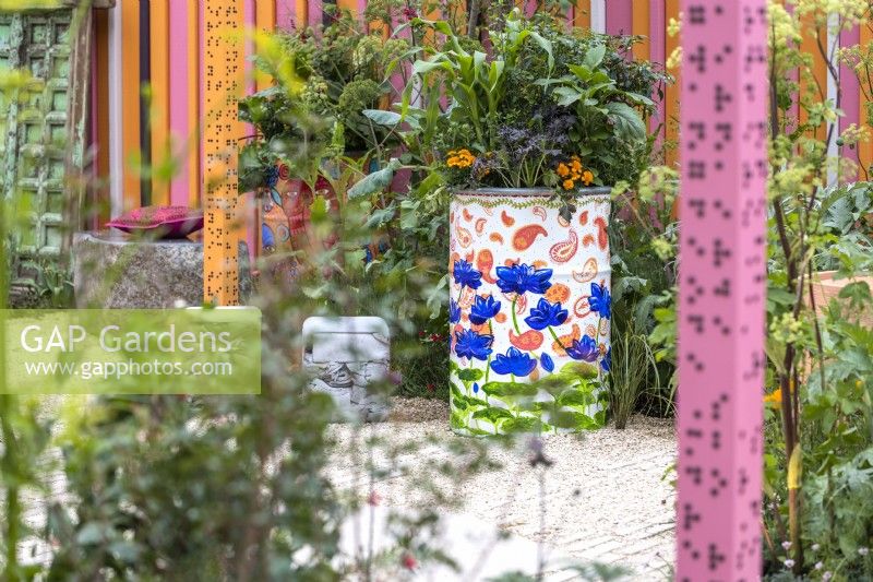 Painted old oil drum planted with vegetables, herbs and flowers. The RHS and Eastern Eye Garden of Unity, designer: Manoj Malde.
