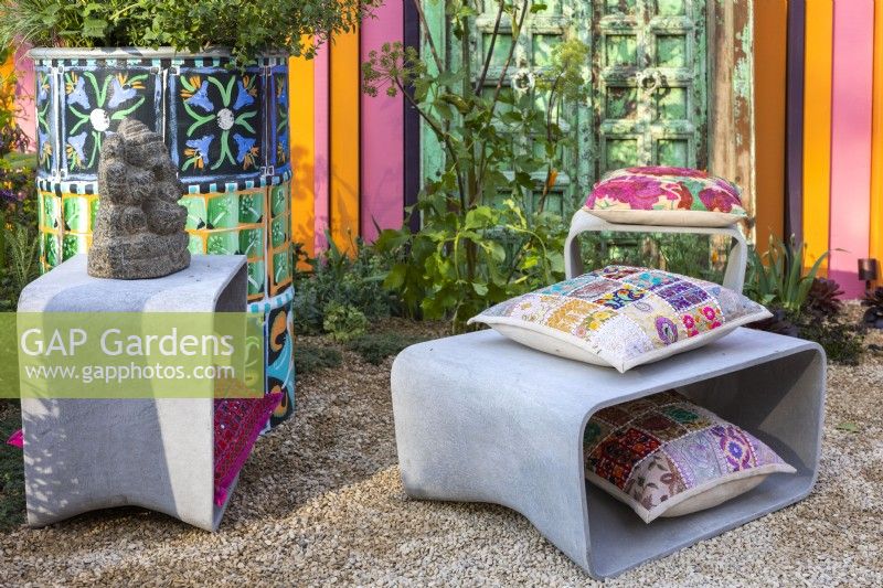 Stool and table made of cement fibre with Indian style, colour cushions. The RHS and Eastern Eye Garden of Unity, designer: Manoj Malde