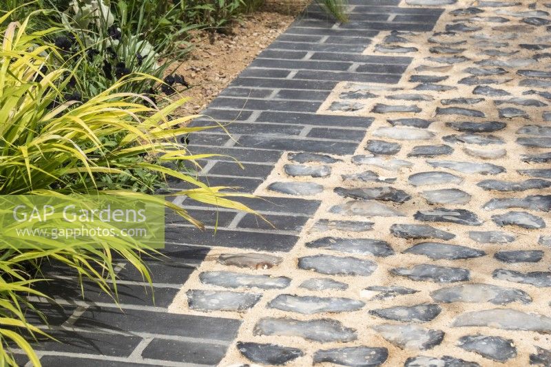 Grey brick and cobbled path with Hakonechloa macra  - designer Lucy Taylor - The Traditional Townhouse Garden -  RHS Hampton Court Palace Garden Festival.