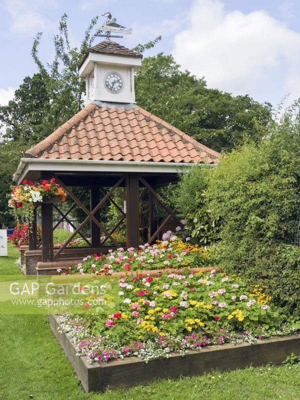 Flower beds and hanging baskets surrounding bus stop at Filby village in bloom Norfolk 2023