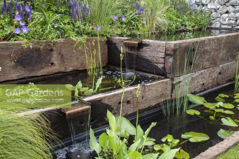 A series of pools made from reclaimed sleepers with water spouts and aquatic plants - - Caroline and Peter Clayton - Get Started Gardens - Nurturing Nature in the City, RHS Hampton Court Palace Garden Festival.