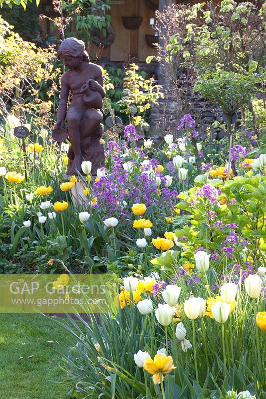 Sculpture surrounded by Tulipa Yellow Pomponette, Tulipa viridiflora Spring Green, Tulipa White Heart, Lunaria annua 
