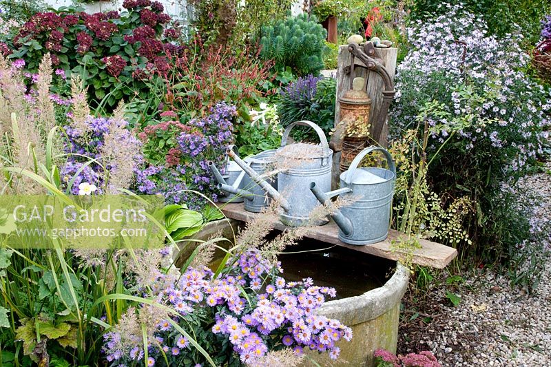Fountain with asters and watering cans 