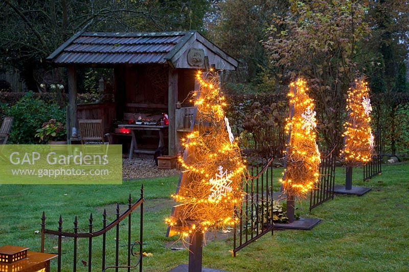 Illuminated Christmas trees made of wooden slats 