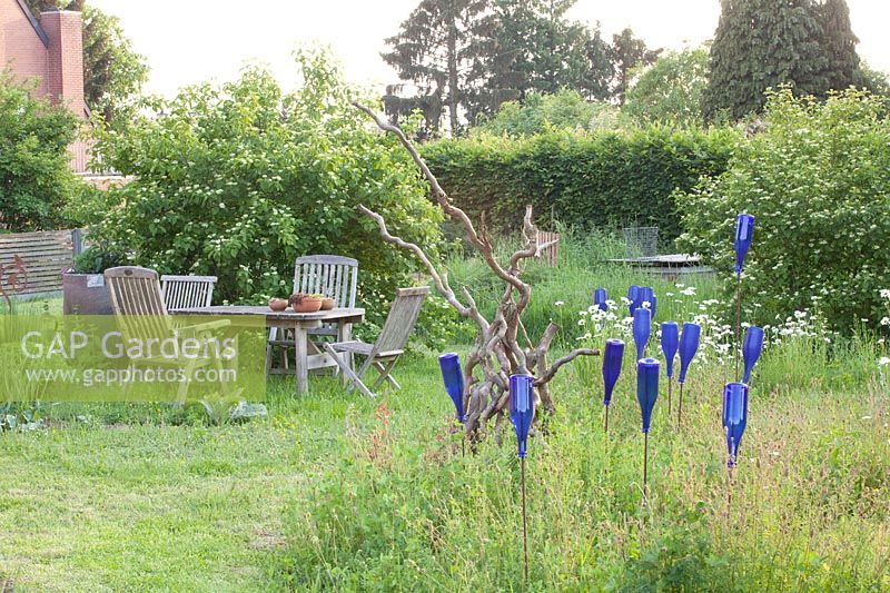 Country garden with seating area in a meadow 
