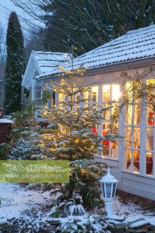 Illuminated garden house in winter 