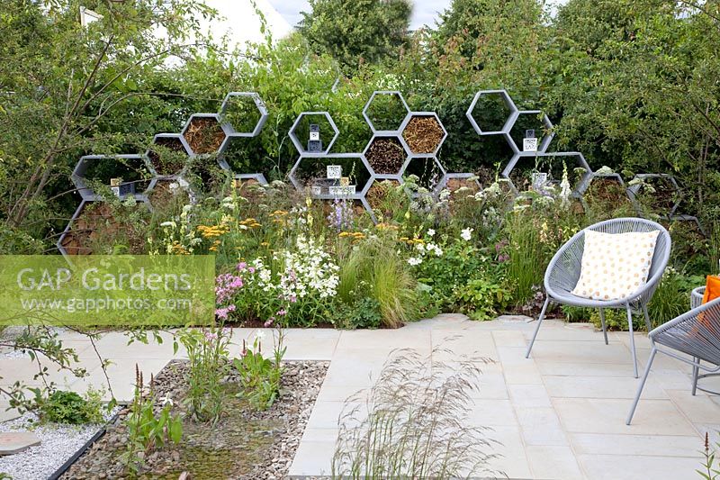 Garden with large insect hotel in the shape of honeycombs 
