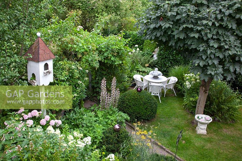 Romantic garden with chestnut tree, seating area and dovecote 