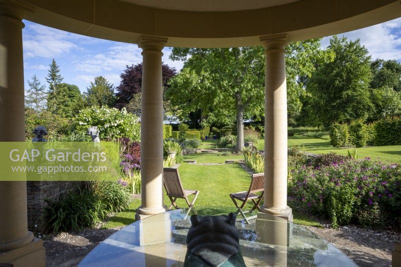 A Temple style summerhouse overlooks a large formal Cotswold garden