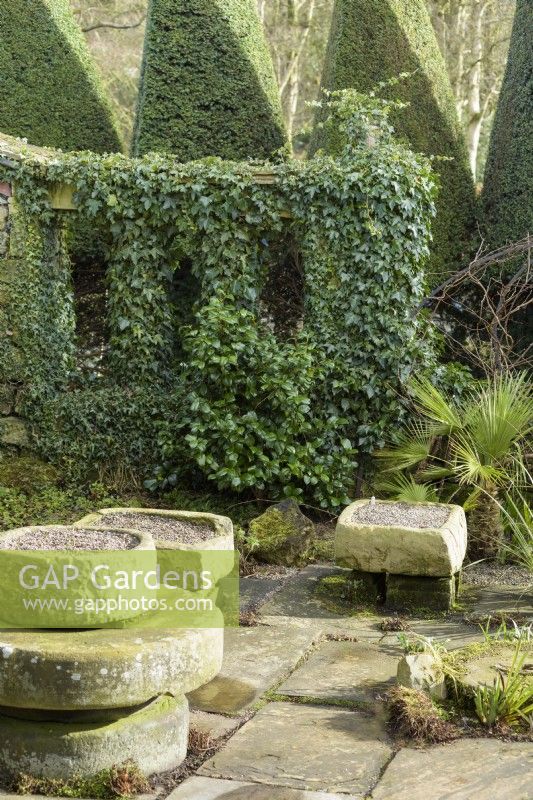 The Paved Garden at York Gate in February framed by an ivy covered screen