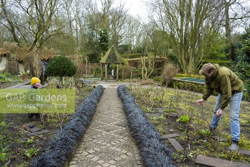 Gardeners constructing hazel supports for herbaceous perennials at York Gate Garden in February
