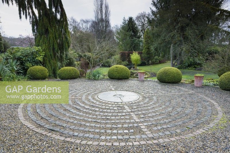 Pavement Maze at York Gate Garden in February surrounded by strongly shaped evergreens including clipped yews.