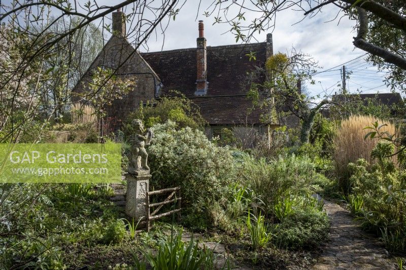 A statue is a focal point in the spring cottage garden at East Lambrook Manor
