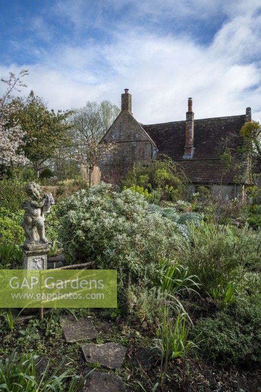 A statue is a focal point in the spring cottage garden at East Lambrook Manor,