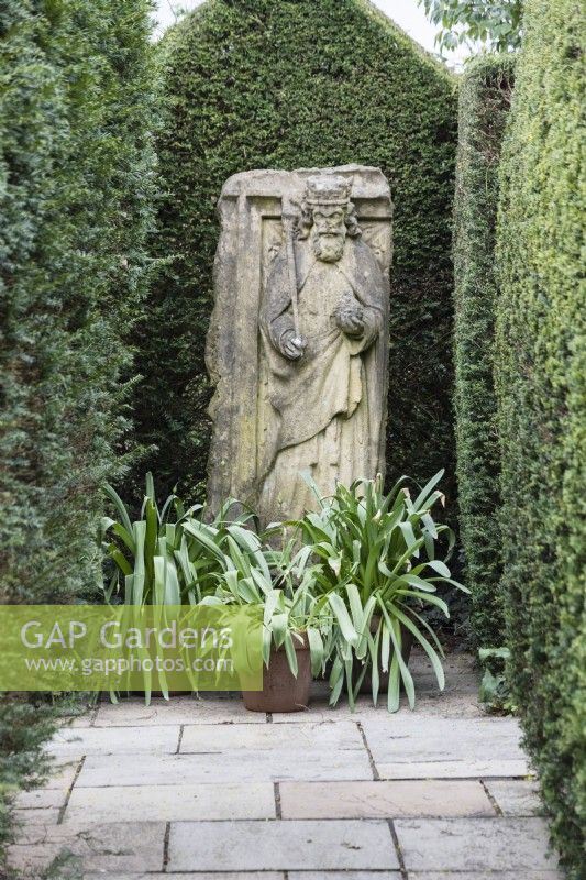 Sculpture of Henry II in the Ashton Arbour. Hedges of clipped Yew. April. Spring.