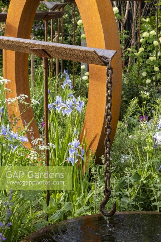 Elevated water feature made from reclaimed steel angle iron with planting including Iris sibirica 'Perry's Blue' - 'Concrete 2.0' - designer Ian McBain - RHS Malvern Spring Festival 2024