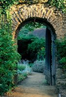 Wall with arched doorway leading to the summer garden at Munstead Wood in Surrey
