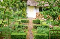 Formal front garden at entrance to cottage with box hedges.