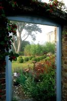 Doorway in wall with view to garden and topiary 